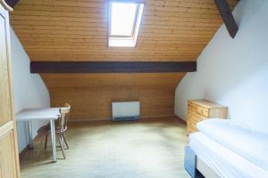 a attic room with a bed and a desk and a window at Speiserestaurant Traube in Küttigen