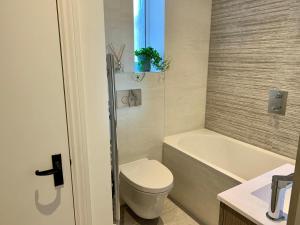 a bathroom with a toilet and a tub and a sink at 1 Central Chambers in Stratford-upon-Avon +7 photos