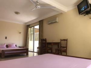 a bedroom with a bed and a tv on the wall at HOTEL MENABE in Morondava