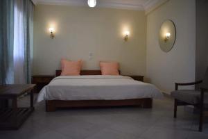 a bedroom with a large bed with pink pillows at HOTEL MENABE in Morondava