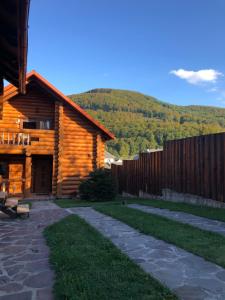 a log cabin with a fence next to a path at Smerekovyi Dvir in Polyana