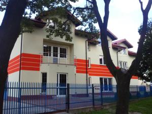 a building with red white and blue stripes on it at Noclegi Pod Kasztanami in Marki