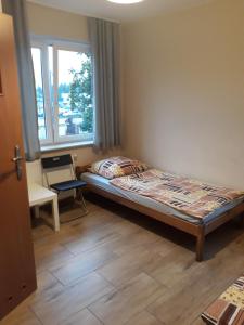 a small bedroom with a bed and a window at Noclegi Pod Kasztanami in Marki