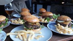 a table topped with plates of hamburgers and french fries at Kozí Farma U Nýdrlů in Stará Červená Voda