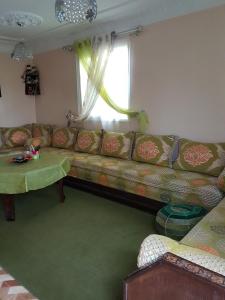 een woonkamer met een bank en een raam bij Location Vacances Casablanca Tamaris in Casablanca