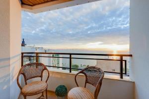 2 stoelen op een balkon met uitzicht op de oceaan bij BHomy Centro Beira-mar norte com linda vista in Florianópolis