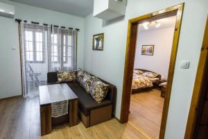 a living room with a couch and a table and a bed at Trapezitsa Apartment - free parking in Veliko Tŭrnovo
