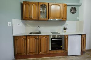 a kitchen with wooden cabinets and a white refrigerator at Апартамент Трапезица in Veliko Tŭrnovo +9 photos