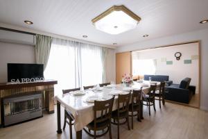 ein Esszimmer mit einem langen Tisch und Stühlen in der Unterkunft Sapporo - House / Vacation STAY 4995 in Sapporo