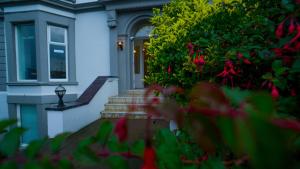 a white house with a door and some flowers at Sandy bottoms in Llandudno