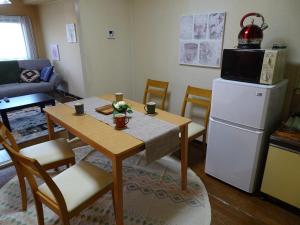 a kitchen and living room with a table and a refrigerator at Merbeil Otsuka / Vacation STAY 4984 in Nikaidō