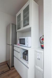 una pequeña cocina con nevera y microondas en Sapporo - House / Vacation STAY 4991 en Sapporo