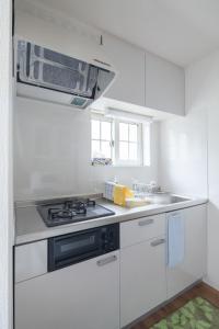 cocina con armarios blancos y fogones en Sapporo - House / Vacation STAY 4991 en Sapporo