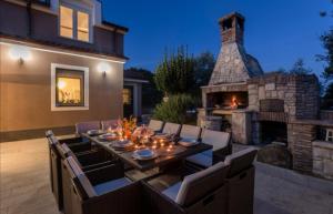a patio with a table and a stone fireplace at Villa Sunshine in Pula