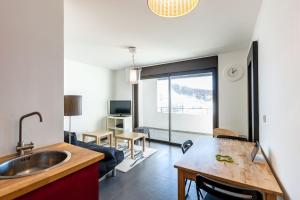 a kitchen with a sink and a living room at Residence Le Valliope in Valberg