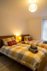 a bedroom with two beds and a chandelier at Sandy bottoms in Llandudno