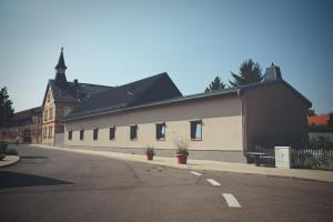 ein weißes Gebäude mit schwarzem Dach auf einer Straße in der Unterkunft Übernacht Erfurt in Erfurt