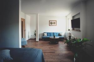 uma sala de estar com um sofá azul e uma televisão em Übernacht Erfurt em Erfurt