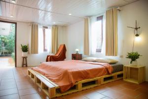 a bedroom with a bed in a room with windows at Dalat 1893 Homestay in Da Lat