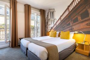 Habitación de hotel con 2 camas con almohadas amarillas en Le 20 Prieuré Hôtel, en París