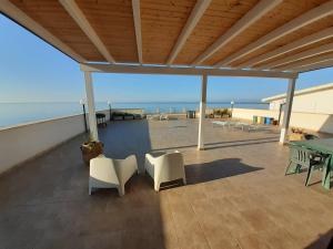 a patio with a table and chairs and the ocean at Mare d'Amuri in Porto Empedocle