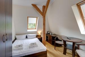 een kleine slaapkamer met een bed en een tafel bij Willa Joka in Międzyzdroje