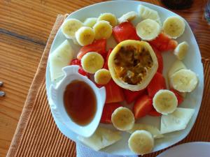 a white plate topped with a bowl of fruit and vegetables at B&B Aparthotel La Isleta in Las Galeras