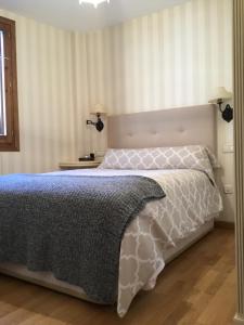 1 dormitorio con 1 cama con edredón gris y blanco en LA COMA DE ALBA -NUEVO-, en Benasque