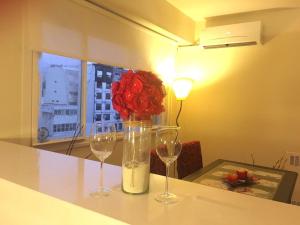 dwa kieliszki do wina i wazon z kwiatem w obiekcie Luminous Studio, amazing view. Hearth of Downtown. w BuenosAires