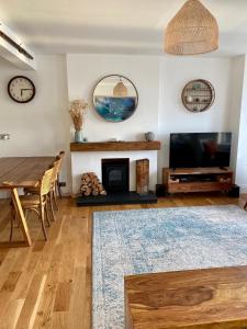 a living room with a fireplace and a tv and a table at The Promenade, Portstewart in Portstewart