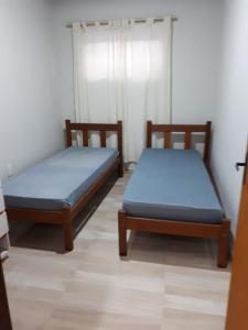 Dos camas en una habitación con sábanas azules. en Monsal Casa para Temporada, en Florianópolis