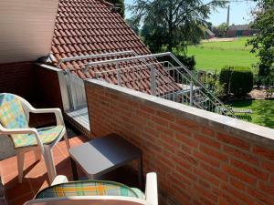 a patio with two chairs and a table and a brick wall at Ferienwohnung nahe Bentheimer Wald in Schüttorf