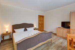 a bedroom with a large bed and a tv at Willa Joka in Międzyzdroje