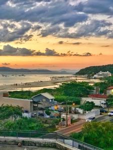 a view of a beach and the ocean at sunset at Apartamento beira mar em Ponta das Canas in Florianópolis