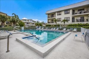 a swimming pool in front of a building at Gulf Watch 204 Condo in Bradenton Beach