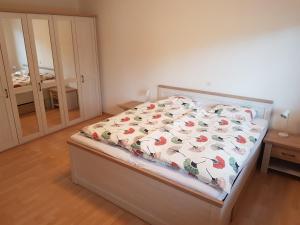 1 dormitorio con 1 cama con colcha de flores en Gästehaus Luma, en Egerkingen