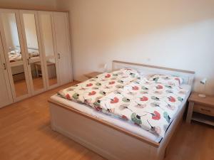 1 Schlafzimmer mit einem Bett mit Blumenbettdecke in der Unterkunft Gästehaus Luma in Egerkingen