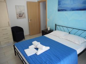Un dormitorio con una cama azul con toallas. en Anatoli, en Agia Pelagia - Citera