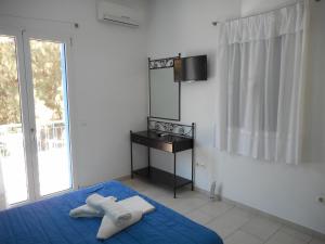 a bedroom with a blue bed and a mirror at Anatoli in Agia Pelagia Kythira