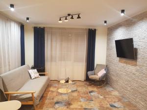 a living room with a couch and a tv at Royal House Apartment in Kyiv