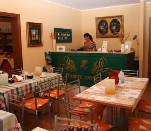 ヴィッラフランカ・ディ・ヴェローナにあるAlbergo Corte Anticaのレストランのカウンターに立つ女