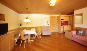 a kitchen and living room with a table and chairs at Residence Belavista in Corvara in Badia