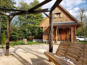 a wooden cabin with a bench in front of it at Vodenica Vrelo Chalets in Vrelo Koreničko