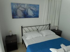 a bedroom with a bed and a painting on the wall at Anatoli in Agia Pelagia