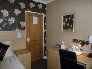 a room with a bedroom with a desk and a bed at Trivelles Park Hotel in Preston