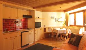a kitchen with a table and a kitchen with a dining room at Residence Belavista in Corvara in Badia