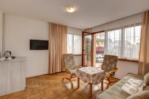 a living room with a couch and a table and chairs at Willa Drako in Międzyzdroje