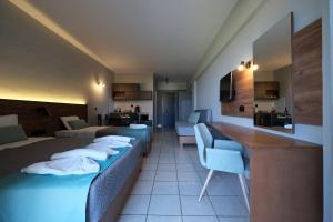 ein Hotelzimmer mit 2 Betten, einem Tisch und Stühlen in der Unterkunft Poledas Apartments in Georgioupoli