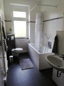 een badkamer met een bad, een toilet en een wastafel bij Ferienwohnung "OTTO" in Erfurt