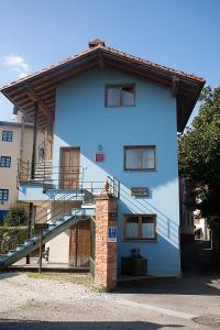 un edificio azul con escaleras en el costado en Apartamentos Cuevas del Mar, en Nueva de Llanes